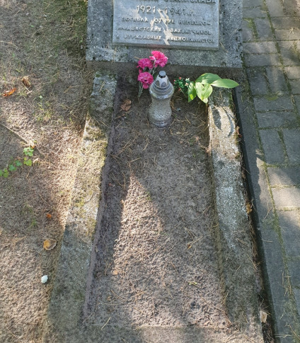 Grób Wacława i Adama Sikorskich na cmentarzu katolickim. Kamienny krzyż stoi na czele, z dwiema tablicami inskrypcyjnymi. Grób otoczony drzewami i opadłymi liśćmi.