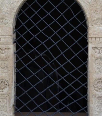 Okno renesansowego portalu z odrestaurowanymi kratami żelaznymi w kościele pw. Narodzenia NMP w Stryju, z dekoracyjnymi rzeźbieniami w kamieniu.