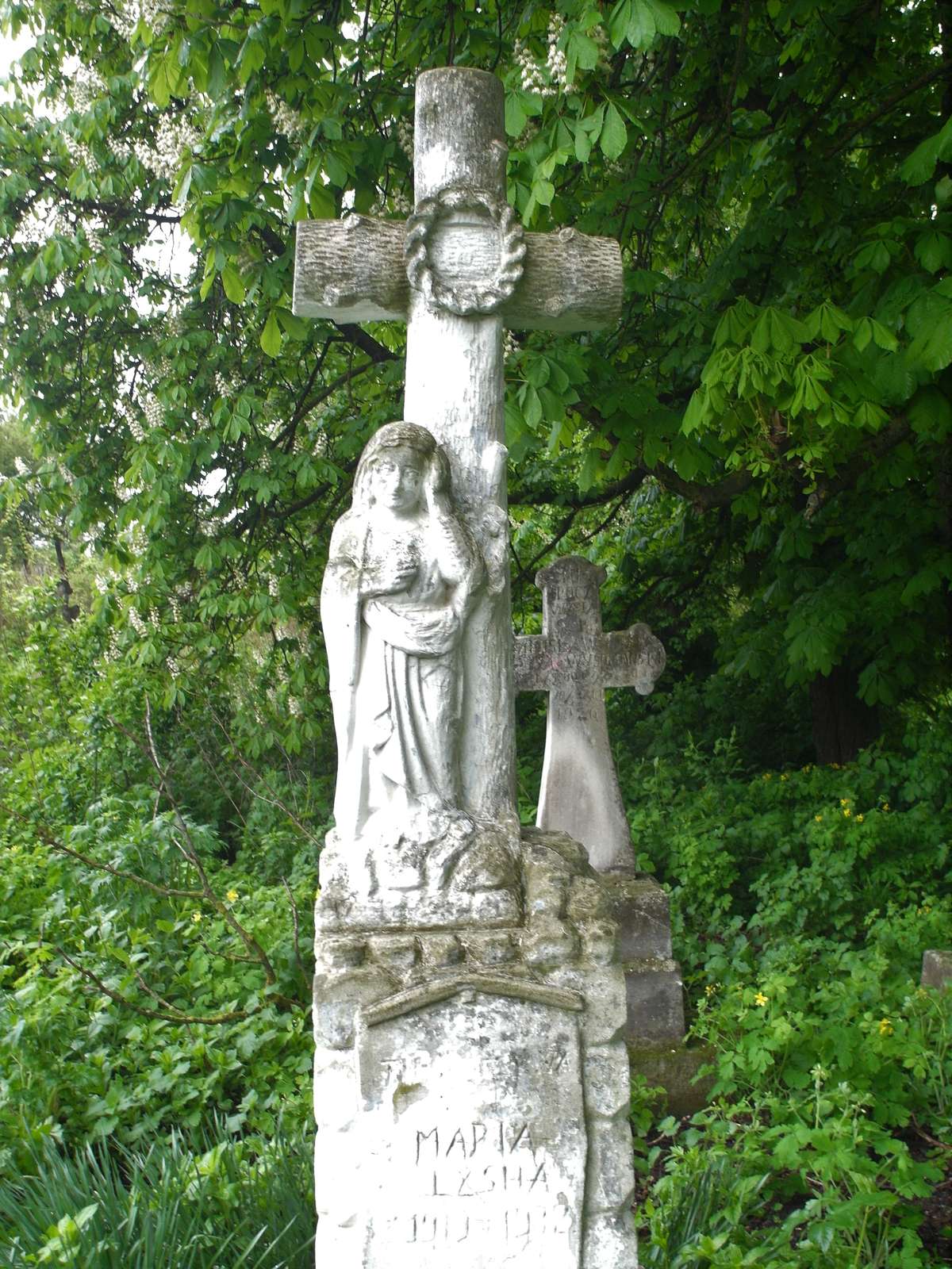 Statue and cross from the gravestone of Maria Lyska, cemetery in Oprylovce