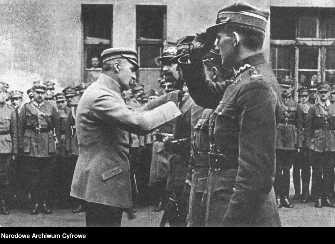 Józef Piłsudski odznacza oficerów krzyżem Virtuti Militarii V kl. od lewej: gen. Tadeusza Jordan Rozwadowskiego, gen. Stanisława Hallera, płk. Tadeusza Piskora, płk. Cedrica Eralda Fauntleroy'a - dowódcę 7. Eskadry Lotniczej im. T. Kościuszki przed gmachem Sztabu Generalnego WP na pl. Saskim., 1920, fot. Narodowe Archiwum Cyfrowe