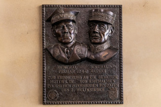 Brązowa tablica z reliefowymi portretami generałów Bronisława Prugara-Ketlinga i Henriego Guisana w Huttwil. Napis w języku niemieckim upamiętnia ich spotkanie 22 kwietnia 1941 roku. Zawiera herby dywizji i kantonu.