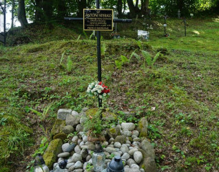 Grób Antoniego Sidełko, polskiego strażnika granicznego, na starym cmentarzu w Mniszku. Grób oznaczony metalowym krzyżem z tabliczką, otoczony kamieniami i zniczami.