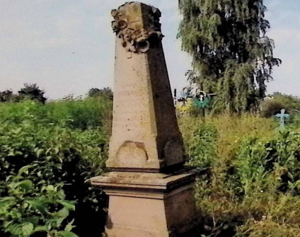 Nagrobek Anny, Janiny i Zofii Niessner z obeliskiem na dwustopniowym cokole. Obelisk z rzeźbionym krzyżem i wieńcem z róż i polnych kwiatów. Otoczony zielenią.