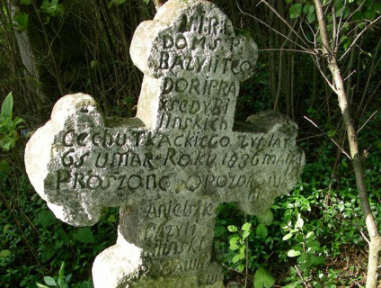 Wapienny krzyż oznaczający grób Praksedy i Bazylego Teodora Bilińskich. Krzyż z trójlistnymi zakończeniami i mniejszym krzyżem na przecięciu. Inskrypcja z przodu oraz INRI nad czaszką z piszczelami.