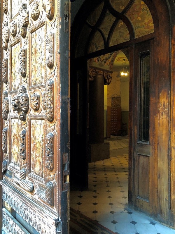 Вхід до будівлі з південно-західного боку вулиці Ладо Гудіашвілі через двері з багатою різьбою по дереву та внутрішній вестибюль