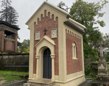 Kamienny relief z koronowaną głową na ceglanej ścianie kaplicy Jaworskich na cmentarzu Łyczakowskim we Lwowie.