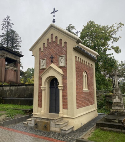 Kamienny relief z koronowaną głową na ceglanej ścianie kaplicy Jaworskich na cmentarzu Łyczakowskim we Lwowie.
