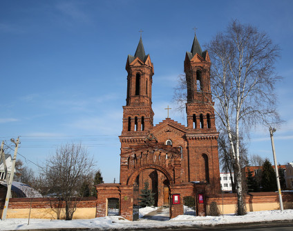 Fasada kościoła św. Barbary w Witebsku z dwiema wysokimi wieżami z cegły i centralnym wejściem ozdobionym krzyżem. Budynek ma łukowe okna i dekoracyjne cegły.