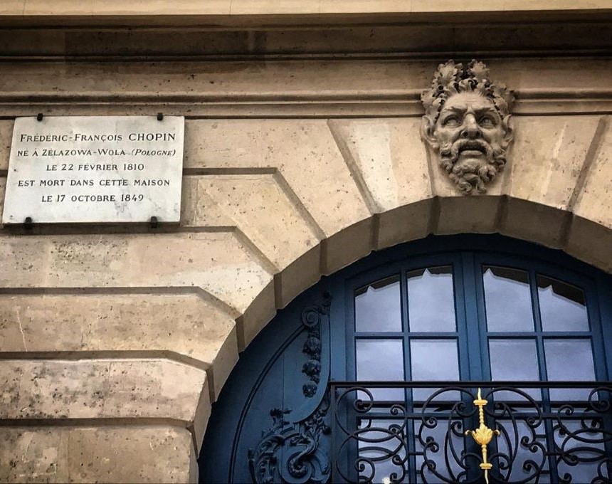 Меморіальна дошка на честь перебування Фридерика Шопена в Парижі на фасаді будинку. Напис французькою мовою сповіщає про його народження у Желязовій Волі та смерть там же 17 жовтня 1849 р. Декоративне кам'яне обличчя над блакитним вікном.