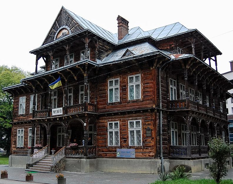 Вілла Гоплана в Трускавці, Україна, дерев'яна будівля з елементами закопанського стилю, з українським прапором і написом 'Музей' над входом.
