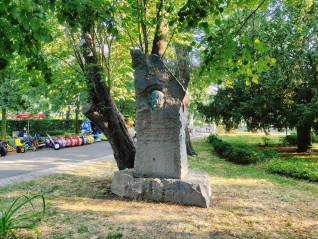 Kamienny pomnik Adama Mickiewicza w Burgas z wyrytym profilem poety oraz jego imieniem i datami urodzenia i śmierci. Otoczony drzewami w parku.