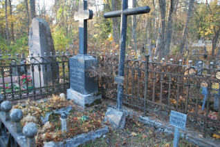 Grób Wincentego Zaleskiego z betonowym obramowaniem i metalowym krzyżem z tabliczką inskrypcyjną. Otoczony żelaznym ogrodzeniem, wokół rozrzucone jesienne liście.