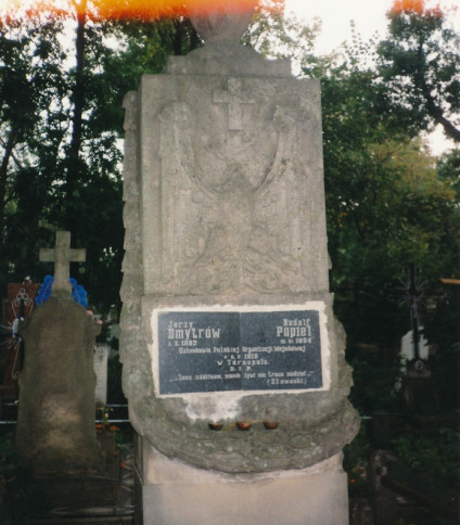 Nagrobek Jerzego Dmytrówa i Rudolfa Popiela, członków Polskiej Organizacji Wojskowej, rozstrzelanych w 1919 roku. Kamień z inskrypcjami i krzyżem, otoczony drzewami.