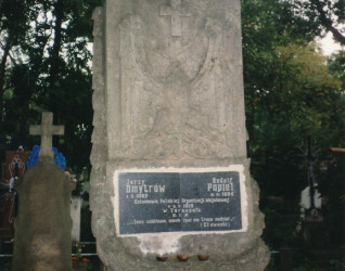 Nagrobek Jerzego Dmytrówa i Rudolfa Popiela, członków Polskiej Organizacji Wojskowej, rozstrzelanych w 1919 roku. Kamień z inskrypcjami i krzyżem, otoczony drzewami.