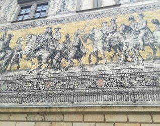 Porcelanowy mural 'Orszak książęcy' na Langer Gang w Dreźnie, przedstawiający władców Saksonii, w tym królów Polski Augusta II i III. Poniżej herby, w tym Polski i Litwy.
