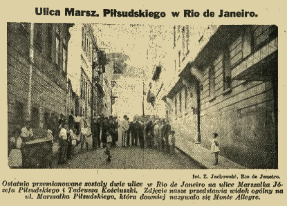Photographie en noir et blanc de la rue Marszałek Piłsudski à Rio de Janeiro, 1936. Des personnes se tiennent le long de la rue étroite bordée de bâtiments. La rue a été renommée de Monte Allegre.