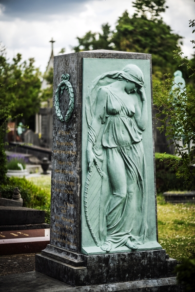 Gravestone of Józef Wieniawski at Ixelles Cemetery in Brussels. The monument features a bronze relief of a woman in classical attire, symbolizing music, and inscriptions in Polish and French.