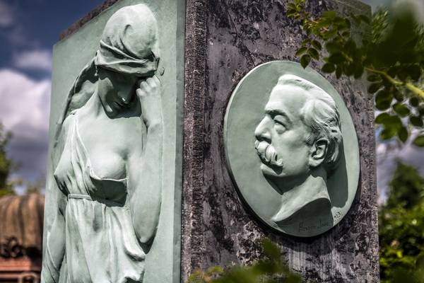 Gravestone of Józef Wieniawski at Ixelles Cemetery in Brussels, featuring a bronze relief of Muse Euterpe and a medallion with Wieniawski's portrait.