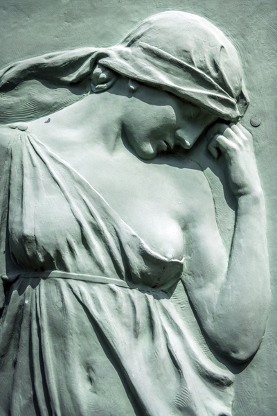 Bronze relief of a woman in a draped garment with a headscarf, head bowed, on Józef Wieniawski's tombstone at Ixelles Cemetery, Brussels.