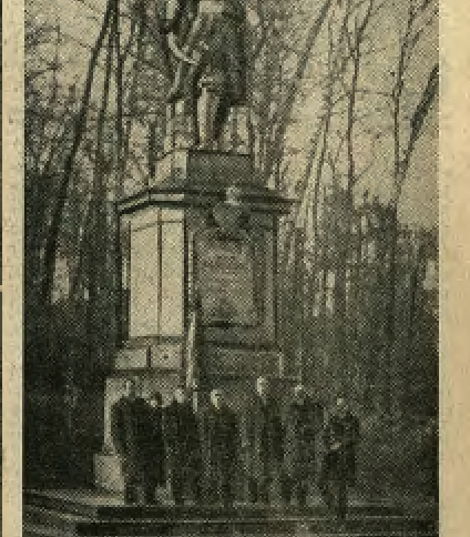 Fotografia z 1936 roku przedstawiająca pomnik Jana Kilińskiego we Lwowie. Posąg stoi na cokole otoczonym drzewami. U podstawy pomnika zgromadzona jest grupa ludzi.