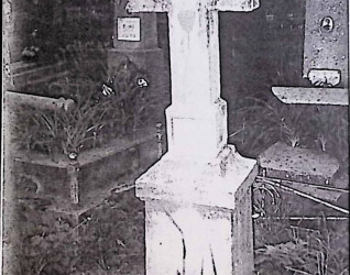 Nagrobek Anieli Piotroskiej z prostym krzyżem na cokole. Krzyż z napisem IHS i płomienistym sercem na skrzyżowaniu ramion. Cokół z rytym napisem z przodu.