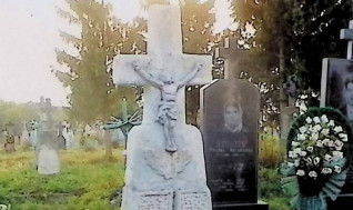 Nagrobek rodziny Dobrzańskich z krzyżem na cokole i dwustopniowej podstawie. Krzyż z żeliwną figurą Chrystusa i płaskorzeźbą liści dębu. Cokół przypomina stos kamieni z nowoczesną metalową tabliczką.