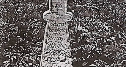 Kamienny krzyż z treflowymi zakończeniami na schodkowej podstawie. Krzyż grecki na pionowej belce. U góry inskrypcja, poniżej mały krzyżyk, następnie kolejna inskrypcja.