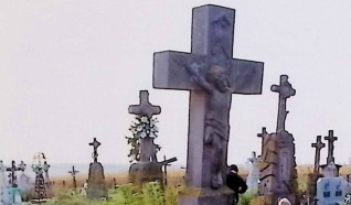 Grób oznaczony krzyżem z postacią Chrystusa i titulus. Poniżej cokół z niszą zawierającą świętą, prawdopodobnie św. Annę, trzymającą księgę z krzyżem. Inskrypcja po lewej stronie.