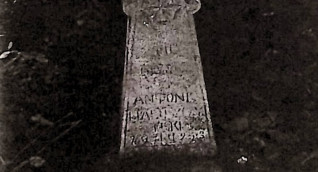 Nagrobek Antoniego Hałuszczyńskiego z krzyżem rozszerzającym się ku dołowi, z rozetami na ramionach i półokrągłymi wałkami. Inskrypcja u podstawy.