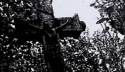 Nagrobek z krzyżem z płaskorzeźbą Ukrzyżowanego Chrystusa, titulusem i czaszką ze skrzyżowanymi piszczelami. Ramiona krzyża rozszerzają się na końcach, zakończone guzami. Cokół z inskrypcją z przodu.