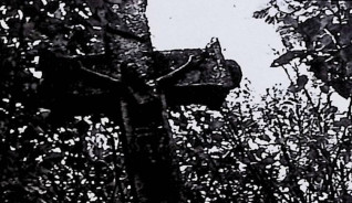 Nagrobek z krzyżem z płaskorzeźbą Ukrzyżowanego Chrystusa, titulusem i czaszką ze skrzyżowanymi piszczelami. Ramiona krzyża rozszerzają się na końcach, zakończone guzami. Cokół z inskrypcją z przodu.