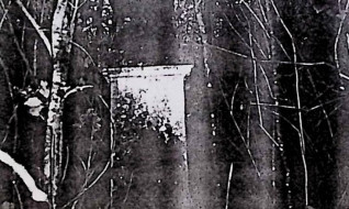 Żeliwny krzyż na kamiennej podstawie z titulusem INRI. W połowie ramienia płytka z kartuszem herbowym i ornamentem roślinnym. U podstawy scena Opłakiwania. Kamienny cokół z prostokątną ramą i rytą inskrypcją.