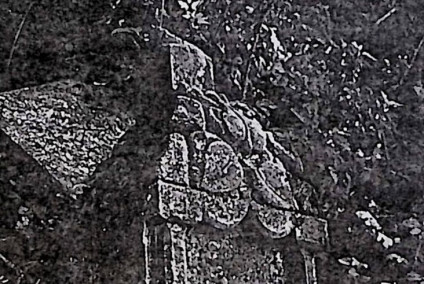 Kamienny cokół z krzyżem na szczycie, otoczony kamieniami. Na wszystkich bokach cokołu płyciny z inskrypcjami.