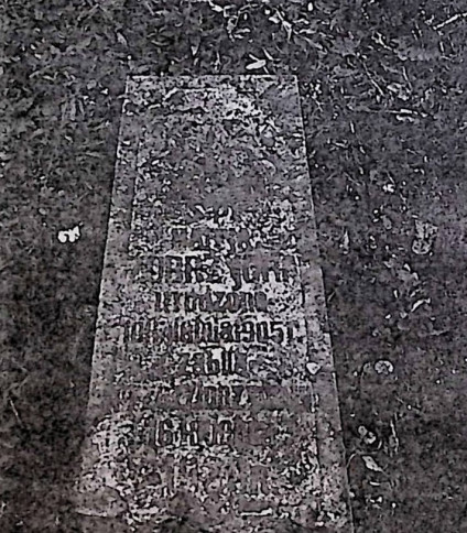 Nagrobek Marii Żóbrzyckiej w kształcie obelisku z wyrytą inskrypcją ujętą w ramę z przodu. Tło inskrypcji ma wcięte naroża.