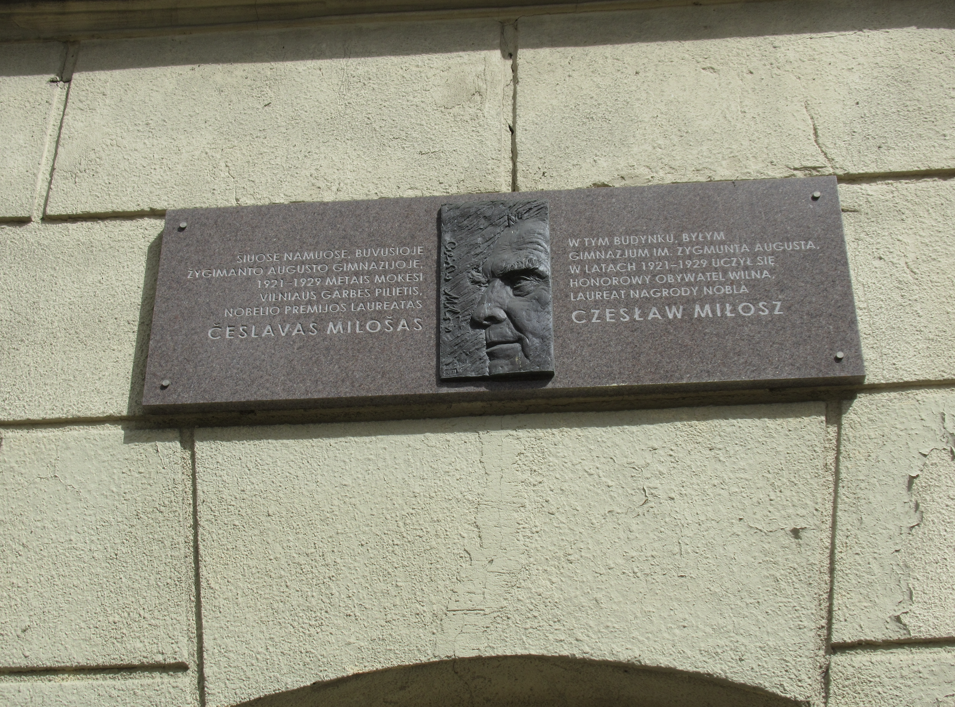 Photo montrant Plaque commémorant Czesław Miłosz sur le bâtiment de l\'ancien gymnase d\'État du roi Sigismond Auguste.