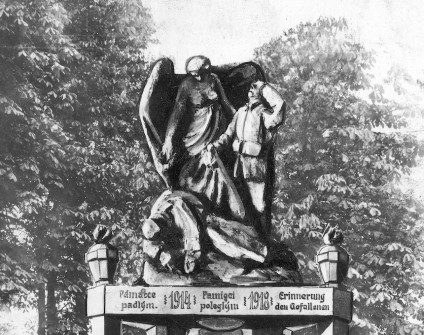 Pomnik I wojny światowej w Karwinie z rzeźbą kobiety-anioła i dwóch żołnierzy, z których jeden patrzy w niebo, a drugi leży u podstawy. Widoczne inskrypcje w językach czeskim, polskim i niemieckim.