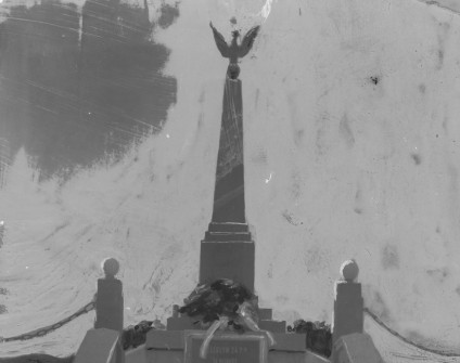 Czarno-biała fotografia pomnika w Łucku upamiętniającego poległych żołnierzy 24 Pułku Piechoty. Obelisk zwieńczony orłem, z tablicą z inskrypcją.