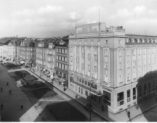 Historyczna fotografia Polskiego Domu Reprezentacyjnego w Czeskim Cieszynie, mieszczącego się w budynku Hotelu Piast. Na fasadzie widoczne napisy 'Towarzystwo Oszczędności i Zaliczek' oraz 'Polonia'.