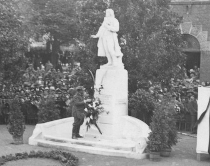 Pomnik Tadeusza Kościuszki w Samborze, 1906. Posąg stoi na cokole z inskrypcjami i płaskorzeźbą jelenia. Osoba składa wieniec u podstawy. W tle zgromadzony tłum.