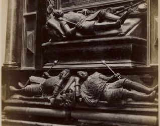 Czarno-biała fotografia dwóch misternie rzeźbionych figur nagrobnych rodziny Sieniawskich w Brzeżanach. Postacie w zbrojach leżą na bokach, trzymając berła.