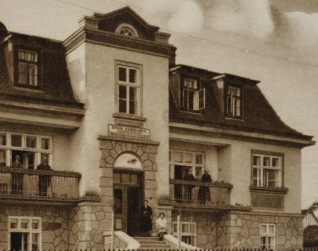 Archiwalne zdjęcie Domu zdrowia dla pracowników Ministerstwa Komunikacji w Truskawcu, 1931. Budynek z centralnym wejściem, kamienną fasadą i balkonami z ludźmi.