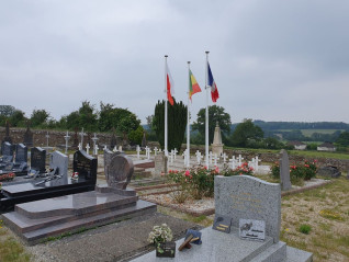 Groby żołnierzy polskich z Błękitnej Armii we Francji na lokalnym cmentarzu w Sillé-le-Guillaume. Białe krzyże oznaczają groby, nad którymi powiewają flagi polska, senegalska i francuska.