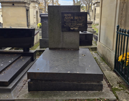 Nagrobek rodzin Benabou i Braunów z płaską podstawą i wysoką prostokątną stelą. Prostokątna płyta z inskrypcjami wystaje z prawej strony. Widoczne otaczające groby i jesienne drzewa.