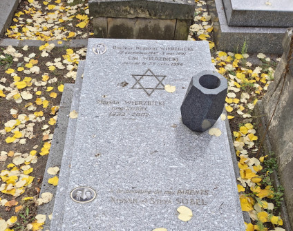Nagrobek Norberta, Chila i Maryli Wierzbickich z Gwiazdą Dawida i inskrypcjami. Widoczne są dwie owalne fotografie na porcelanie. Kamień otaczają opadłe żółte liście.