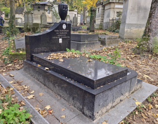 Nagrobek Stelli Rapoport z czarną kamienną podstawą i schodkową płytą. U wezgłowia stela z brązowym wazonem i Gwiazdą Dawida. Widoczna porcelanowa fotografia Stelli Rapoport i inskrypcje.