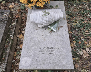 Nagrobek Jacka Vanarskiego z rzeźbą dwóch splecionych rąk na płaskiej płycie. Napis brzmi 'Jack Vanarsky, rzeźbiarz, 1936-2009'. Grób otaczają kwiaty i jesienne liście.