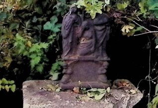 Krzyż żeliwny na dwustopniowym cokole z ramionami w formie roślinnej i wicią akantową. Na przecięciu figura Chrystusa, powyżej titulus, poniżej grupa Opłakiwania z klęczącymi puttami, Matką Boską, św. Janem i św. Marią Magdaleną.