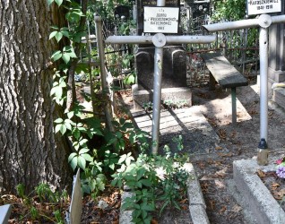 Grób oznaczony stalowym krzyżem rurkowym z metalowym kołem na przecięciu ramion. Powyżej przymocowana metalowa tabliczka z napisem. Grób ujęty opaską.