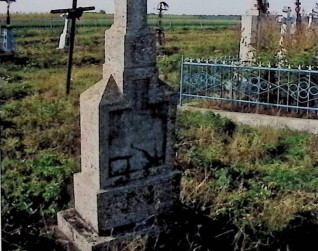 Nagrobek Karola Chemija z krzyżem na dwustopniowym cokole. Krzyż z ramionami zakończonymi guzami i płaskorzeźbą Chrystusa na przecięciu. Cokół z prostokątnym wypiętrzeniem i spłaszczonymi ostrosłupami oraz płytą z inskrypcją.