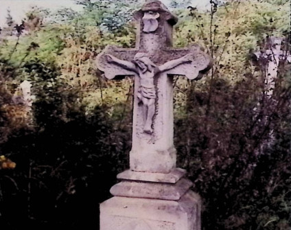 Nagrobek z krzyżem na dwustopniowym cokole. Krzyż ma zakończenia w formie trójliścia i relief Chrystusa. Cokół ma ścięte krawędzie i inskrypcję obwiedzioną żłobkiem.